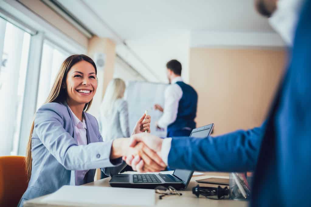 A local mortgage broker shaking hands with a client.