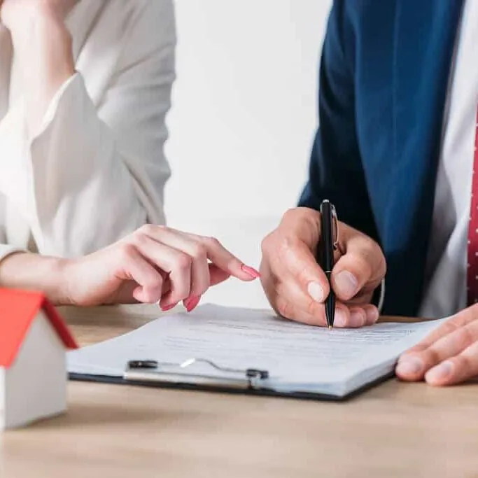 A man in a suit signing a loan for an investment property